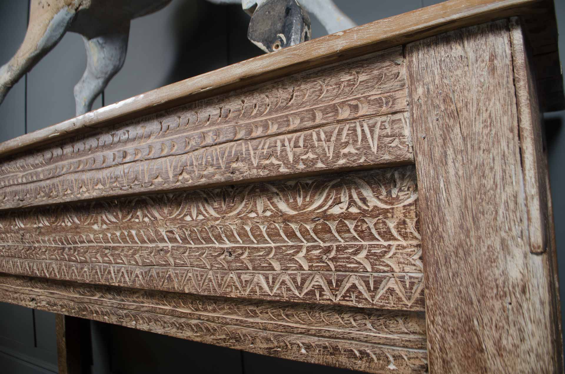 
Decorative carved wooden console table with stretcher base and rustic patina