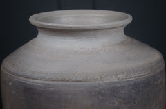 Gray ceramic jar with textured surface on a black background wabi sabi