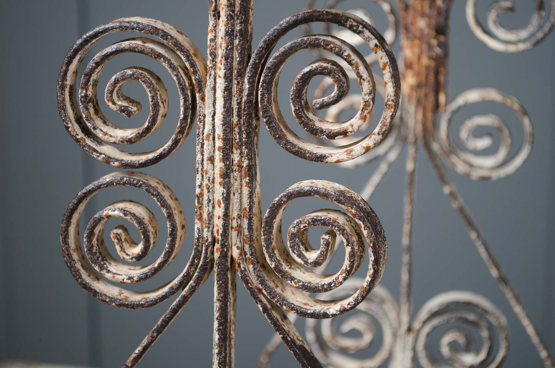 
Close-up of rusted metal scrollwork against a gray background