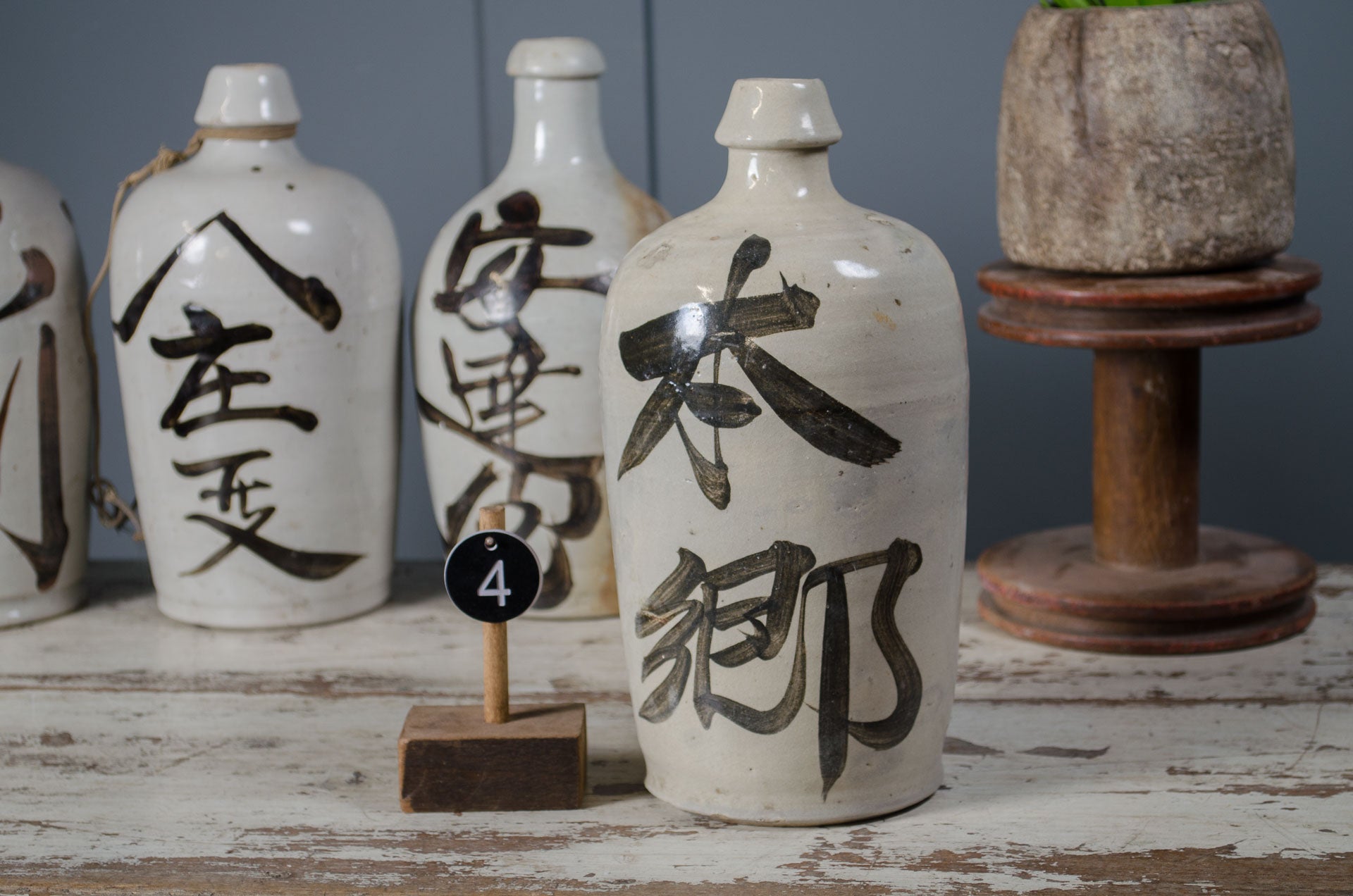 Set of ceramic bottles with black text on a wooden surface