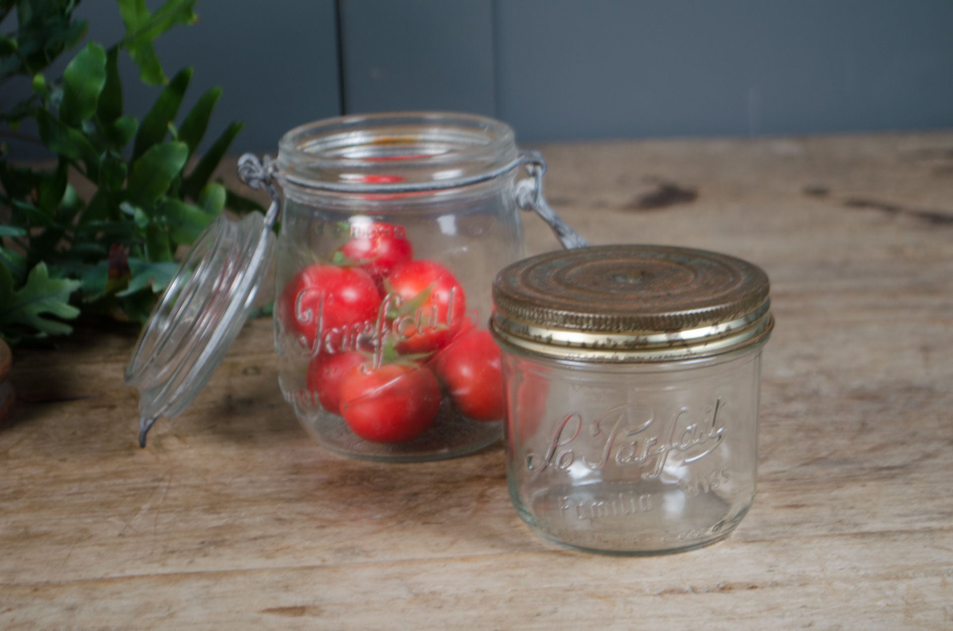 Vintage French Le Parfait glass storage jars with embossed branding and wire fastening lids in assorted sizes.