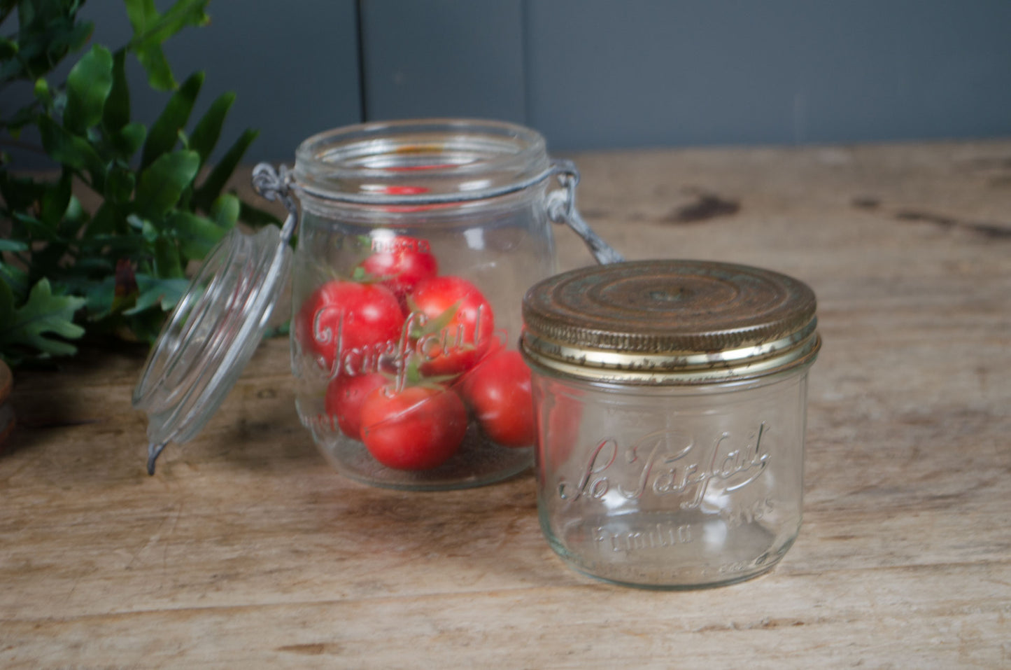Vintage French Le Parfait glass storage jars with embossed branding and wire fastening lids in assorted sizes.