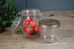 Vintage French Le Parfait glass storage jars with embossed branding and wire fastening lids in assorted sizes.