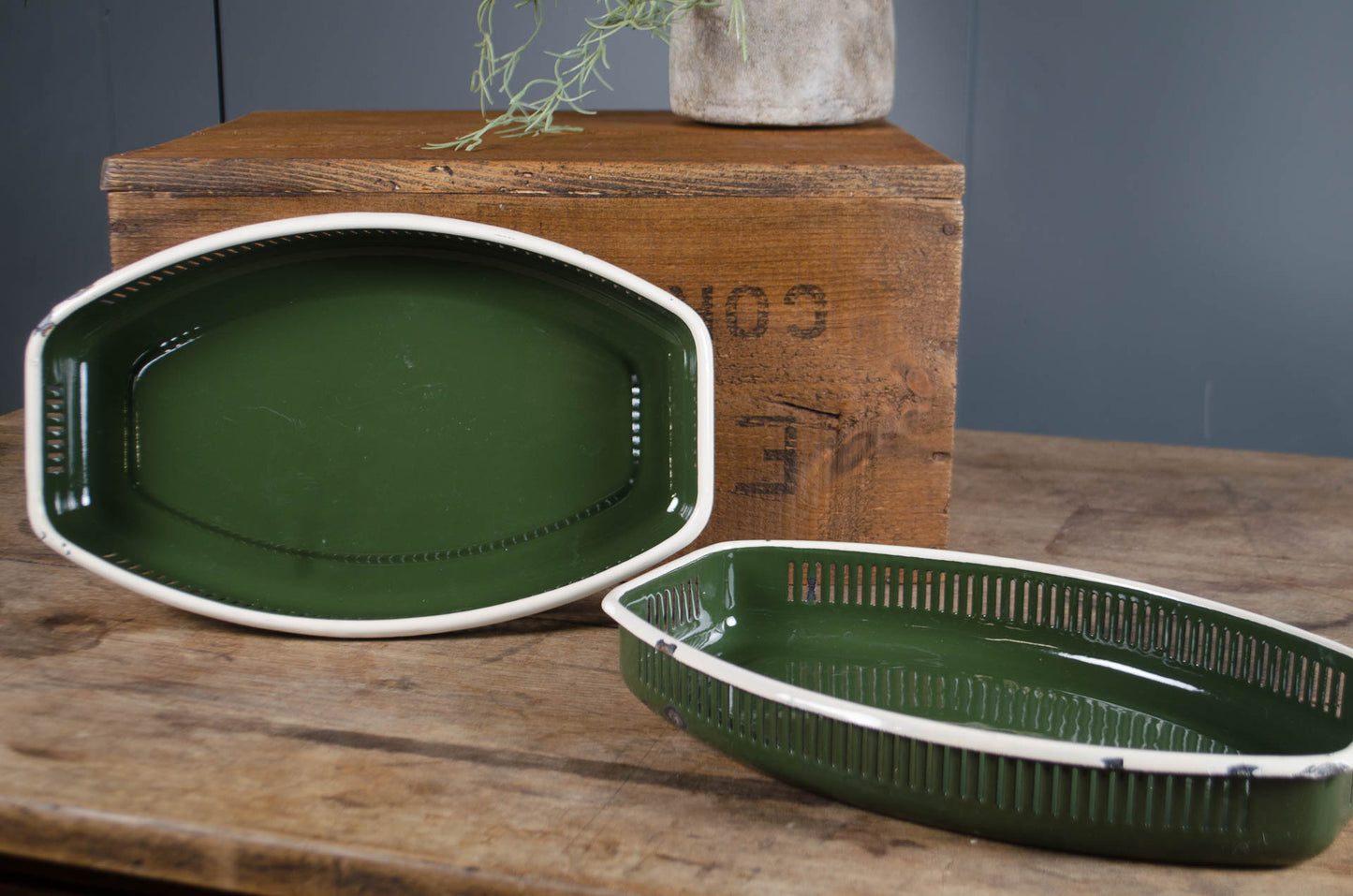 Two green ceramic trays on a wooden surface with a rustic background.