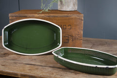 Two green ceramic trays on a wooden surface with a rustic background.