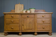 Wooden dresser with antique items against a blue wall