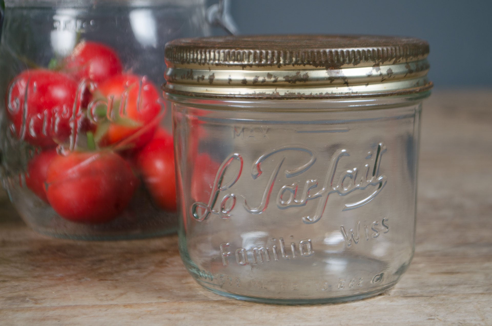 
Vintage French Le Parfait glass storage jars with embossed branding and wire fastening lids in assorted sizes.