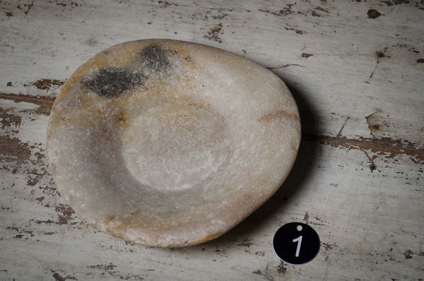 Ancient stone bowl on a textured surface