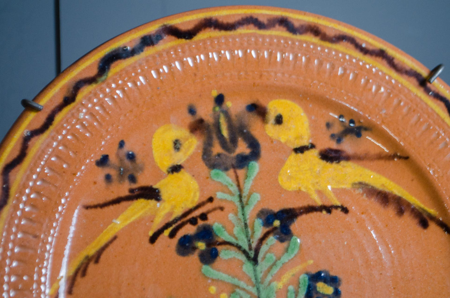 French folk art pottery platter displayed on wooden stand