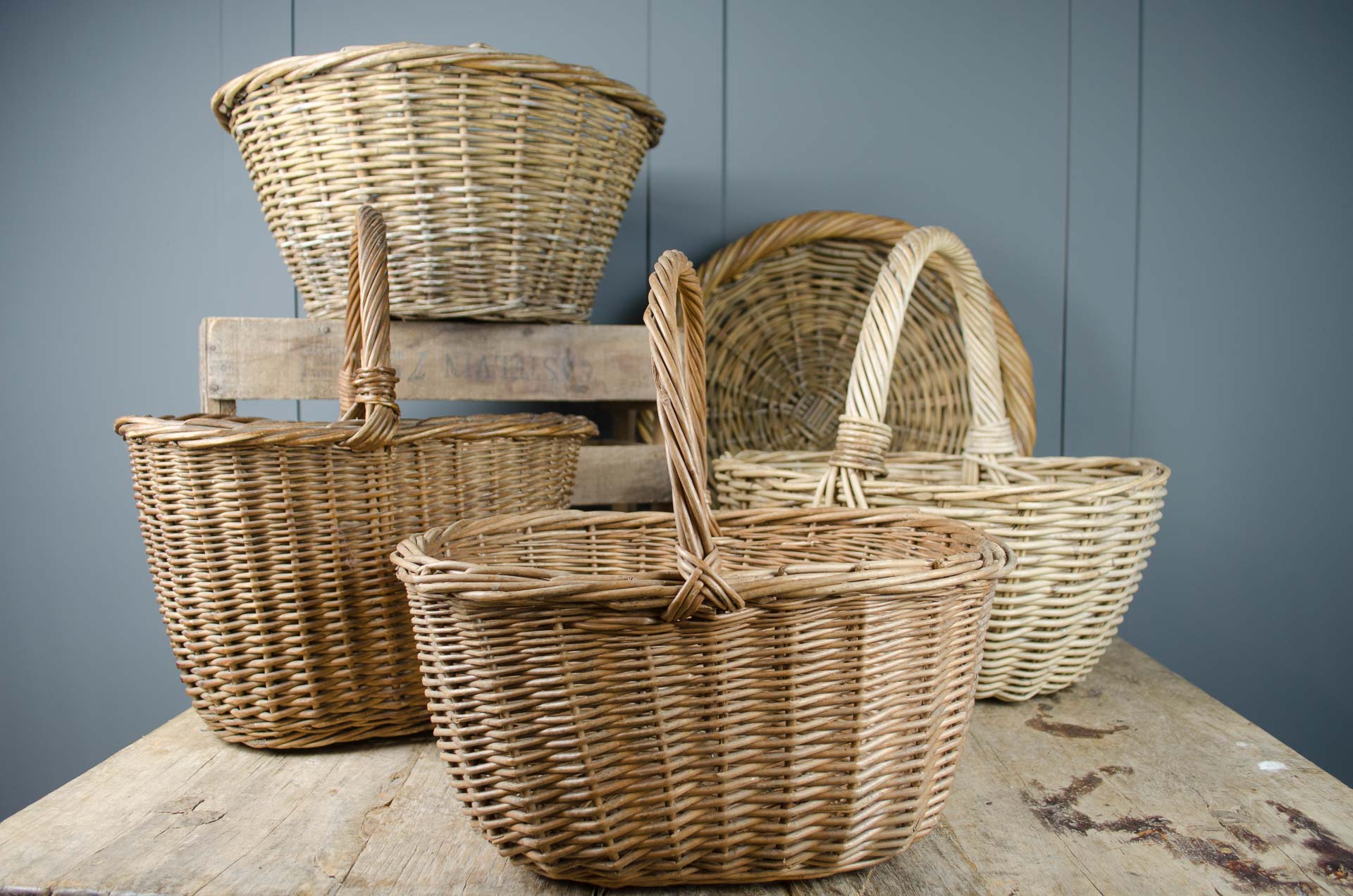 a collection of vintage baskets against a grey background