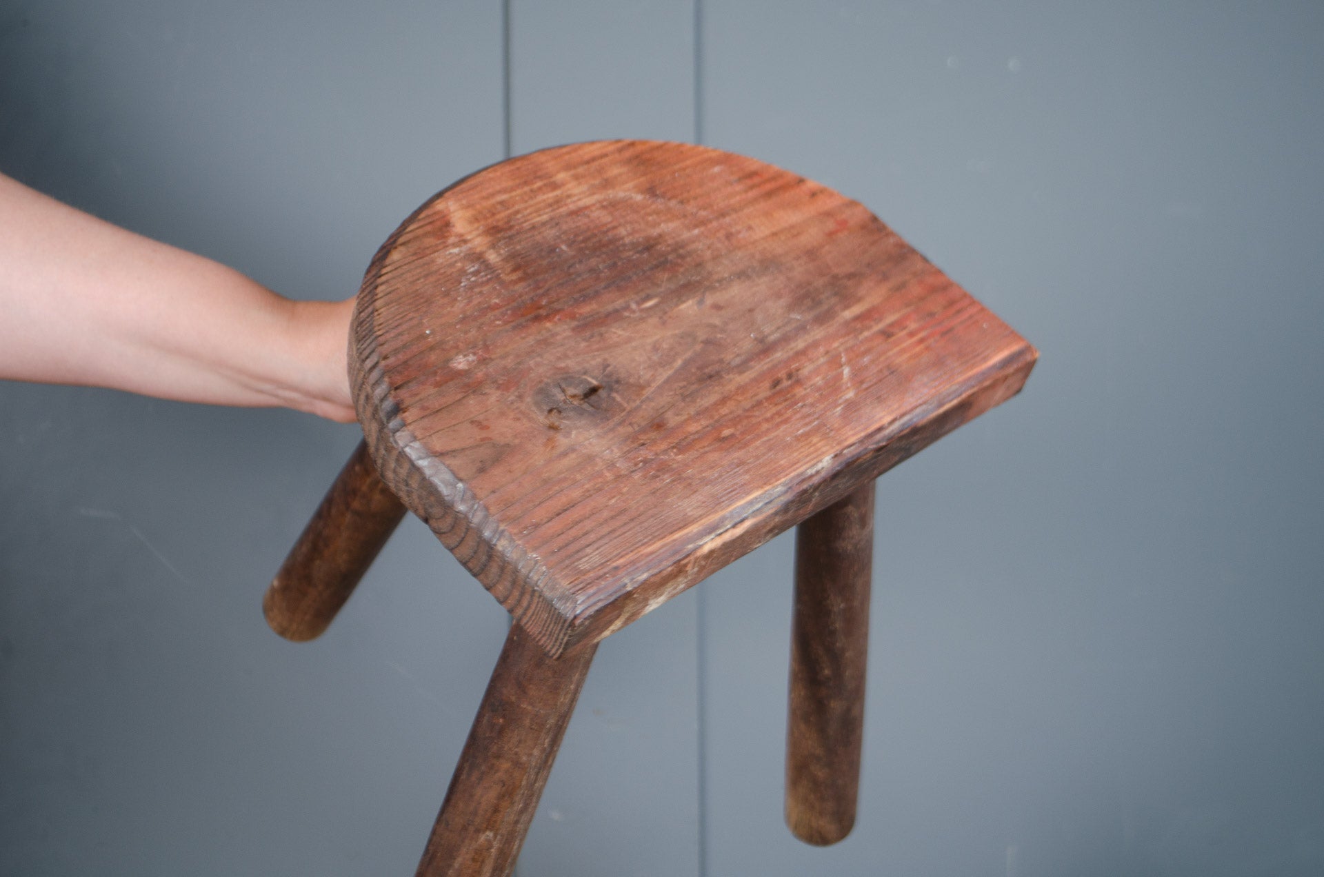 
Rustic French wooden milking stool with three legs and a weathered patina, sourced from France.