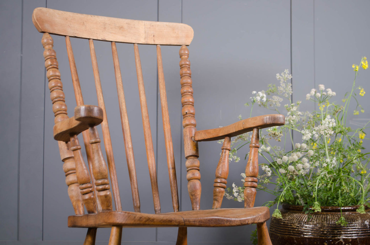 Pine and elm farmhouse armchair styled beside ceramic planter