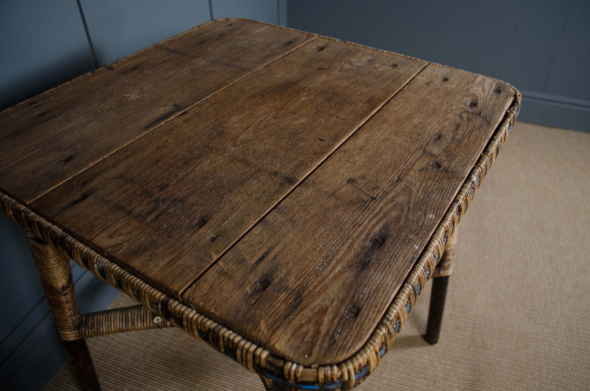 
Wooden table with wicker frame against a blue wall