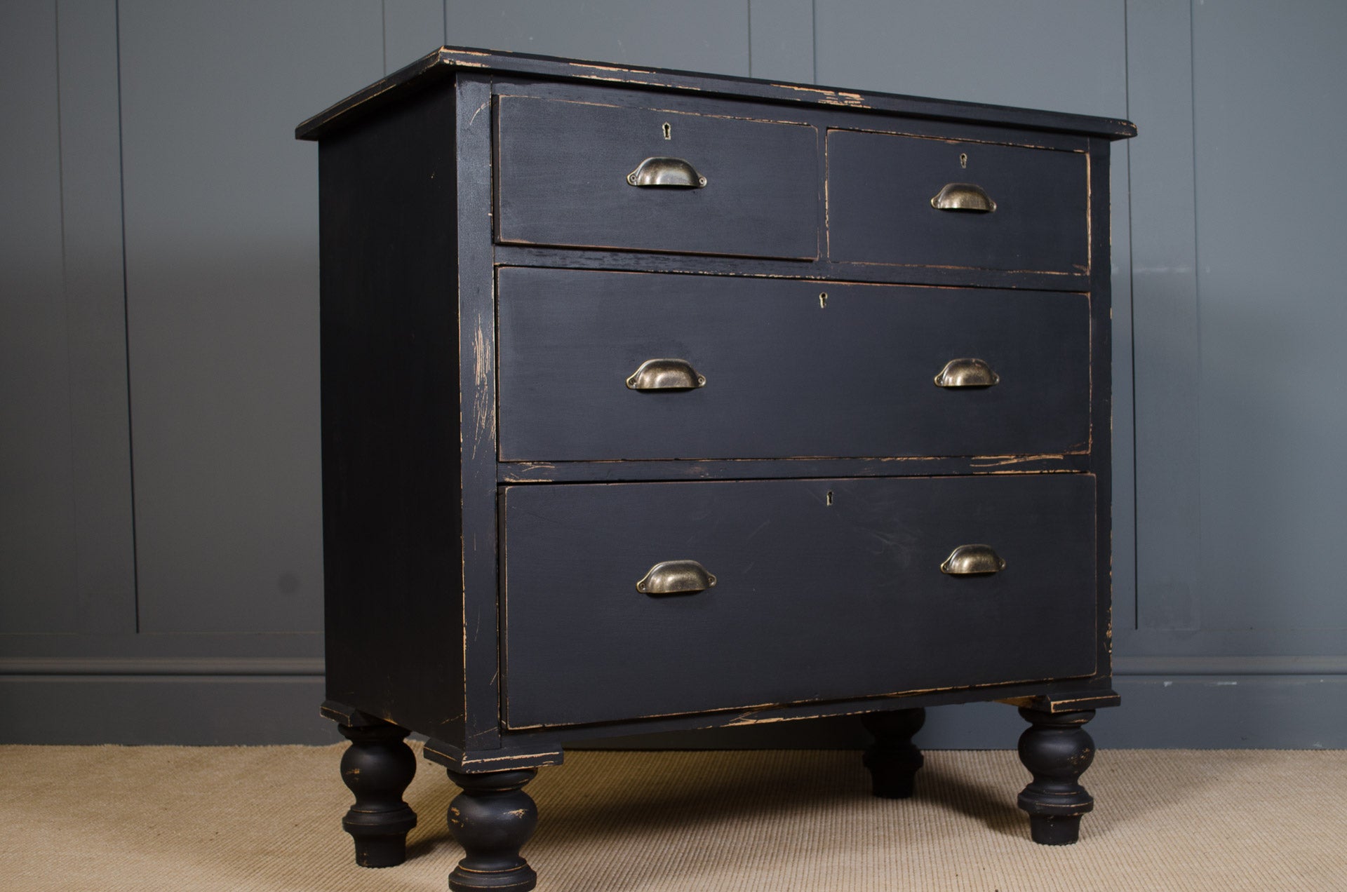 A perfectly proportioned Edwardian solid pine chest with an ebonised worn paint finish and antique brass cup handles