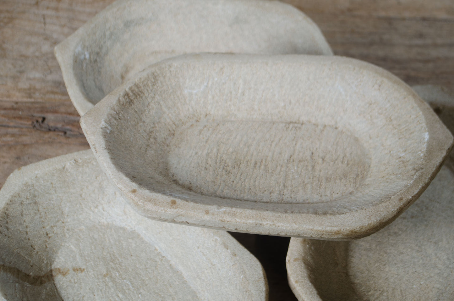 Stack of stone or ceramic bowls on a wooden surface