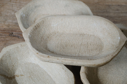 Stack of stone or ceramic bowls on a wooden surface