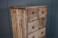 Vintage wooden dresser with peeling paint against a blue wall