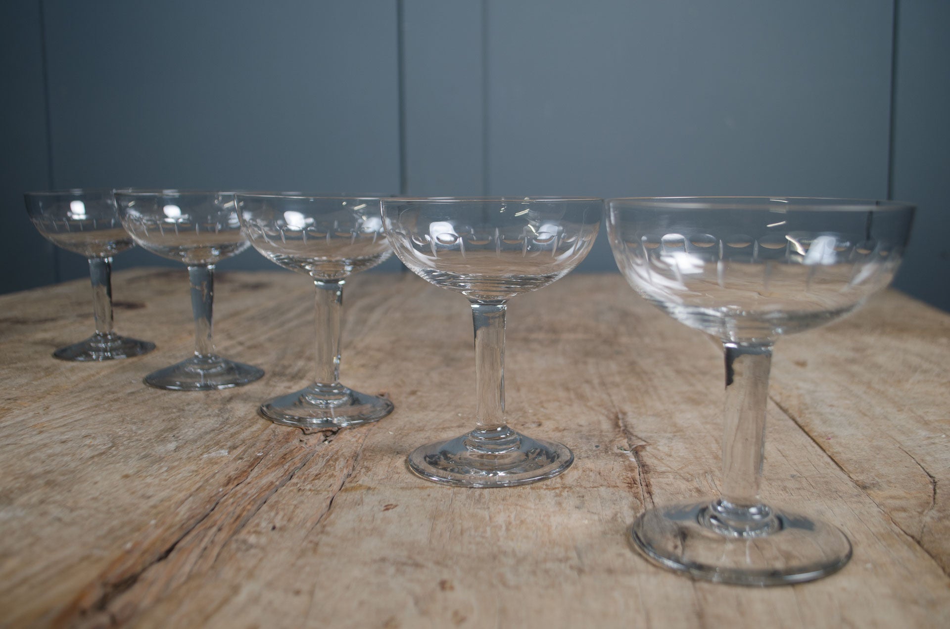 
Clear glass French champagne coupes on wooden table