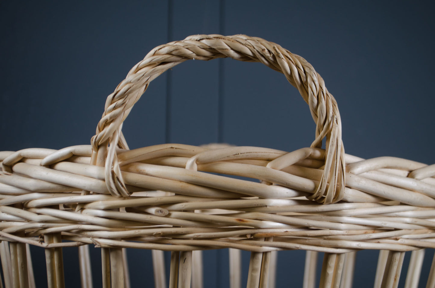 Close-up of a woven basket with a handle against a dark background